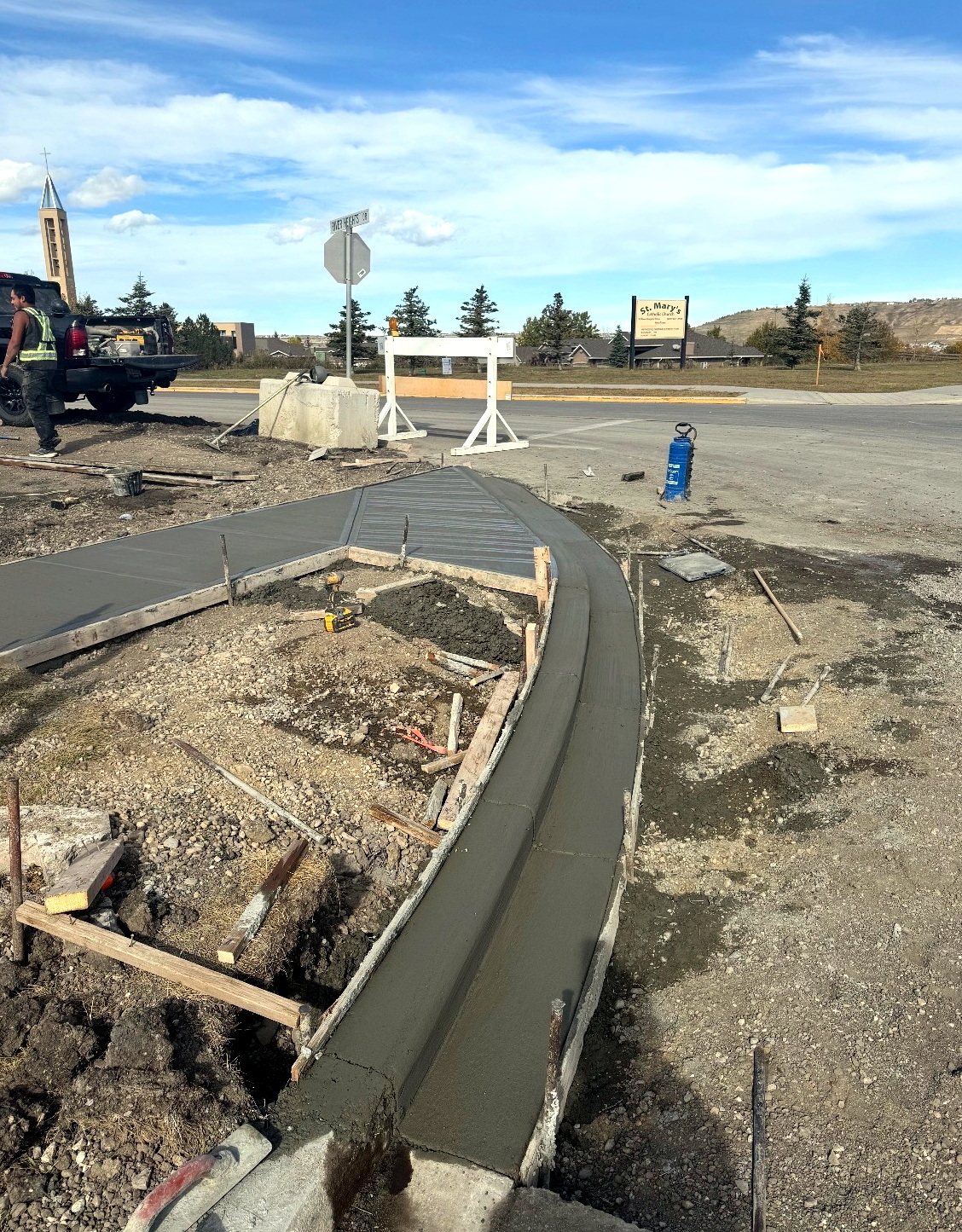 Freshly poured commercial concrete traffic island and curb in wood formwork at a Calgary intersection, placed by SiteWorx Concrete