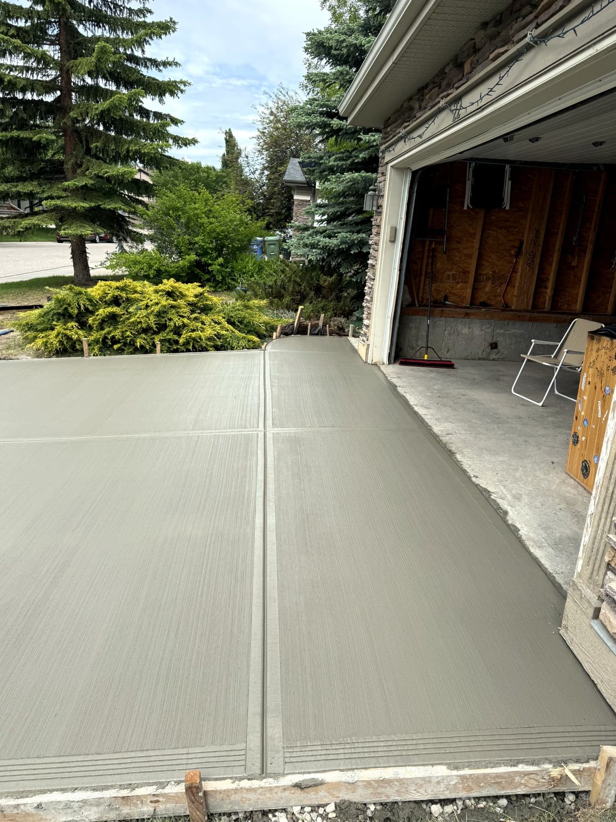 Side view of a broom-finished residential concrete driveway with clean control joints and formed edges, poured by SiteWorx Concrete Calgary